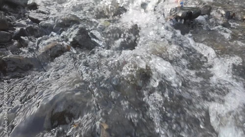 Camera Moving Forward Over Flowing Stream and Rocks