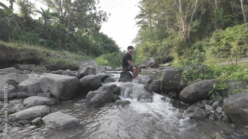 Man Washing His Face and Hands in a Natural Stream