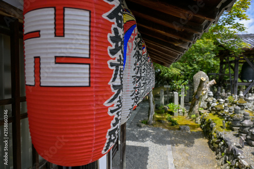 Colorful Paper Lanterns in Front of a Memorial Pavilne Buddhist Statues in the Background at Adashino Nenbutsu-ji Temple, Kyoto, Japan