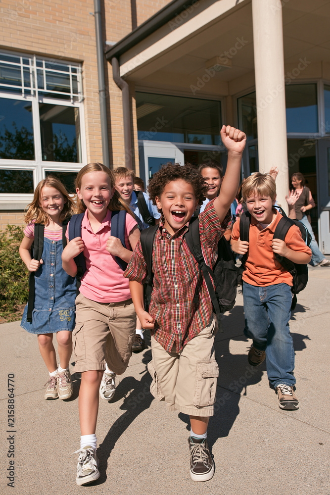Obraz premium Group of Happy Diverse Schoolchildren Running Out of School Building Celebrating End of Class