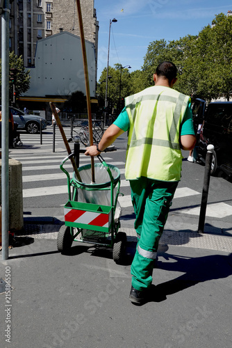 Agent d'entretien de nettoyage urbain avec son chariot de collecte dans la rue