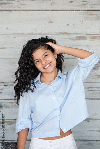 Close-Up Portrait of Smiling Teenage Girl with Curly Hair