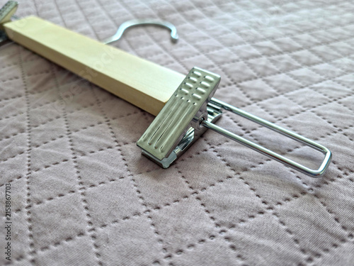Wooden Clothes Hanger with Metal Clamp on Quilted Fabric