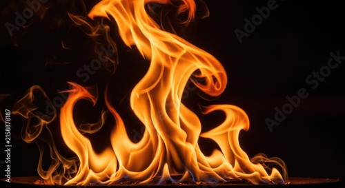 Vibrant orange and yellow flames dance against a stark black background, creating a dynamic and energetic visual.