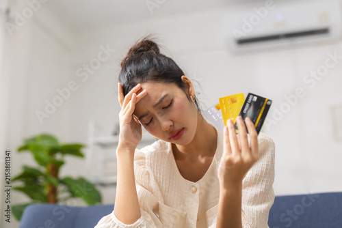 Stressed woman holding credit cards at home, worried about debt, bills, financial problems, overspending, budgeting, loan repayment, personal finance, money management and economic pressure.
