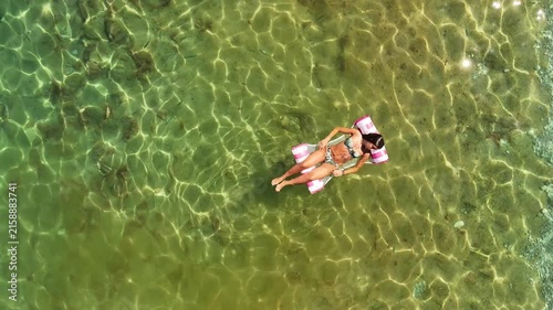 Stunning overhead drone perspective capturing her serene moment of summer bliss against the vast expanse of the pristine ocean