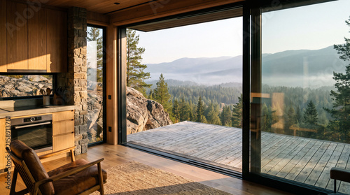 A contemporary wooden living room and kitchen featuring a large sliding glass door opening to a wooden deck with a scenic mountain forest view.