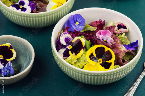 Colorful edible flower salad with mixed lettuce leaves