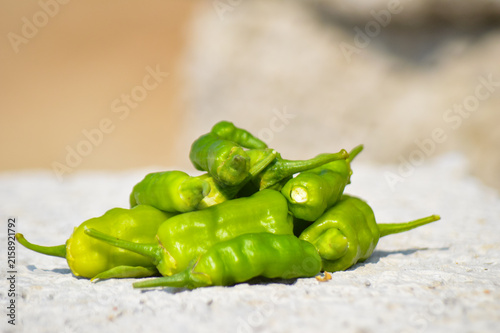 close up of organic green chili peppers on a texture
