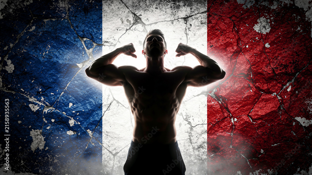 Naklejka premium Muscular man flexing in front of French flag on cracked wall. Bodybuilder silhouette posing against weathered tricolor background. Athletic power and national pride concept for sports media.