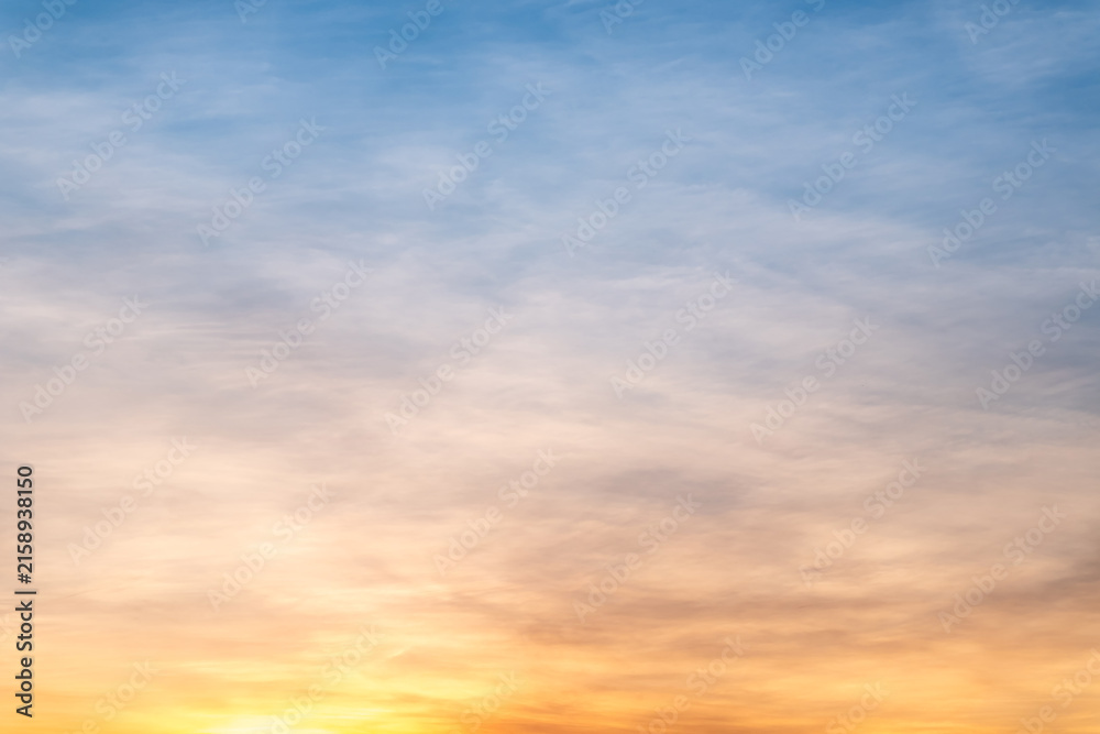 Obraz premium Sky sunset,Beautiful sunrise sky with vibrant gradient orange and gold colors and soft blue, Clear atmosphere with wispy clouds. Peaceful, perfect for background and copy space, High resolution images
