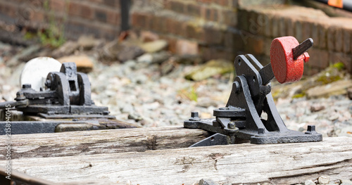 Vintage Railway Switch Lever on Wooden Sleepers by Old Track Mechanism in Rustic Train Yard
