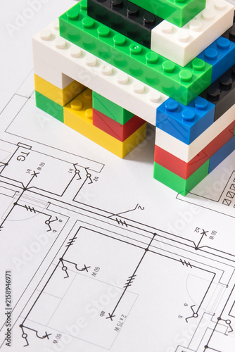 Small house made of toy blocks and electrical diagrams of house. Building home