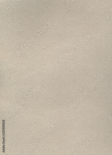 Recycled cardboard paper texture background with subtle fibers and specks creating a natural and rustic backdrop for design projects and crafts.