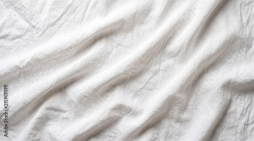 Textured background of a wrinkled white linen fabric with natural folds and soft shadows