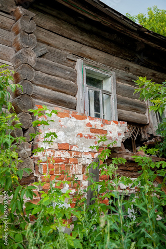 Weathered wooden house with brickwork