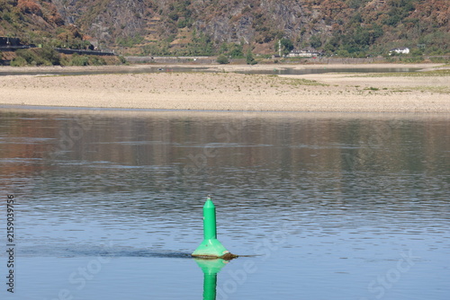 Navigation buoy marking the Rhine channel beside a large exposed gravel bank
