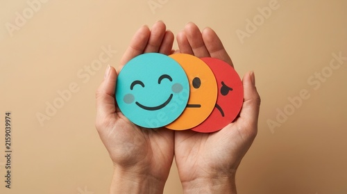 A sad face mask hidden behind a happy one held in hands for depression and mental health awareness.