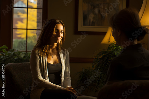 Therapist and client speaking in warmly lit counseling room