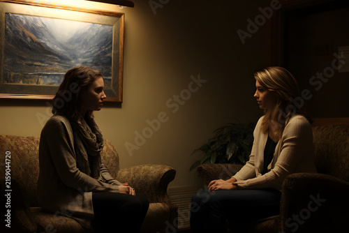Therapist and client seated in warmly lit counseling room