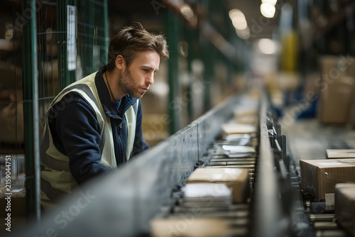 Warehouse Worker Scanning Parcels on Sorting Line
