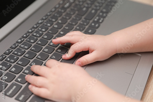 Baby hands typing on a laptop keyboard