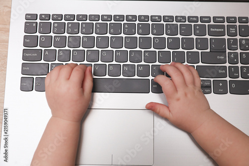 Baby hands typing on a laptop keyboard
