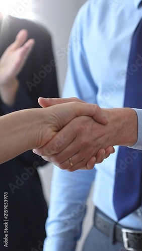 Business people shaking hands, concluding a deal, and celebrating success with an agreement and partnership in a corporate office environment
