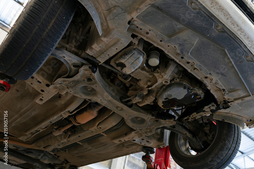 Underside of car on lift in auto repair workshop
