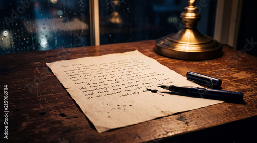 Unfinished handwritten letter beside a fountain pen in a quiet evening setting