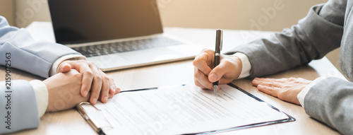 Close up of business people hands signing contract agreement document on clipboard at desk in office, lawyer or businessman putting signature filling corporate legal paperwork form.