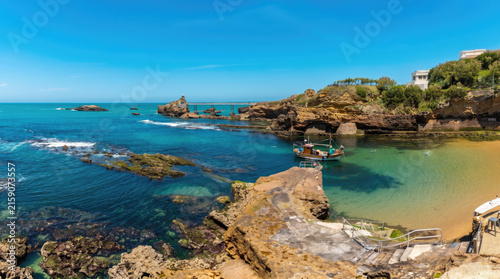 Small fishing boat anchored in a scenic rocky coastal bay with turquoise ocean water