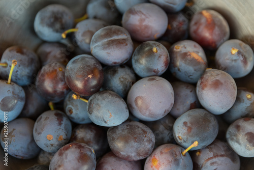 Bild auf Leinwand A close-up view of fresh, ripe plums in a bowl