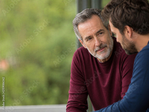 Older Man Listening to Younger Friend During Honest Talk