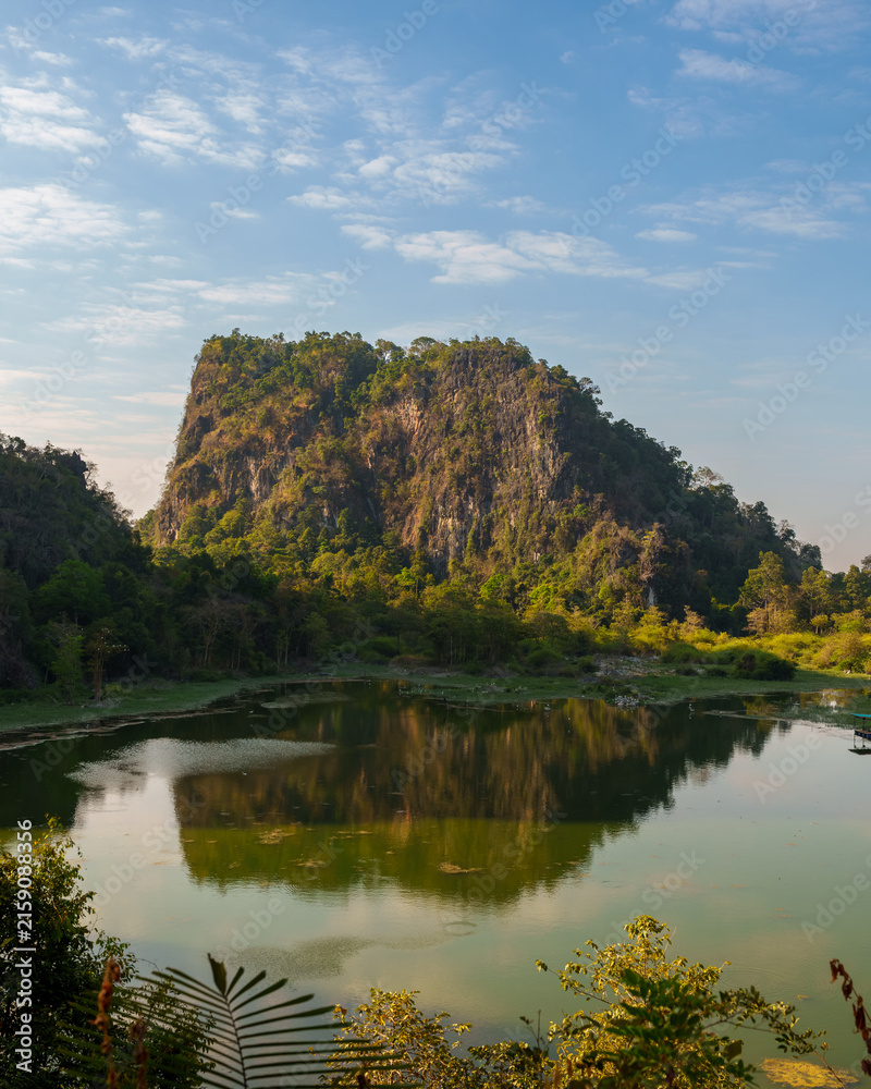 Fototapeta premium Forested Karst Mountain Reflected in Calm Lake
