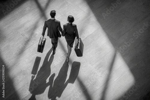 Businessman and Woman Enter Office with Briefcases