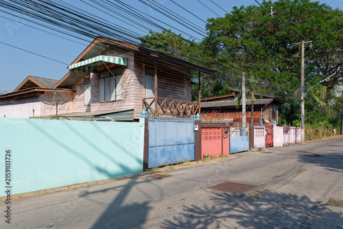 Obraz na płótnie Lampang, Thailand - February 10, 2025: Quiet residential street with colorful fences and wooden house in Lampang
