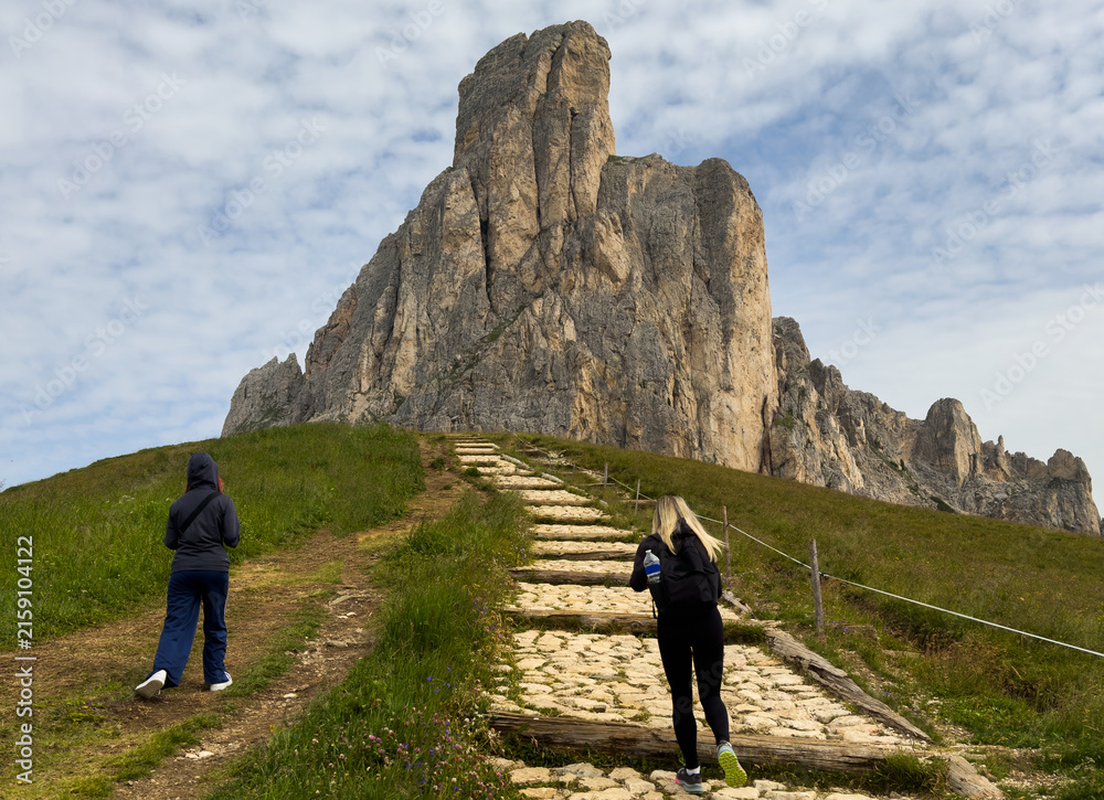 Naklejka premium tourists walking in the dolomites at giau pass in summer italy