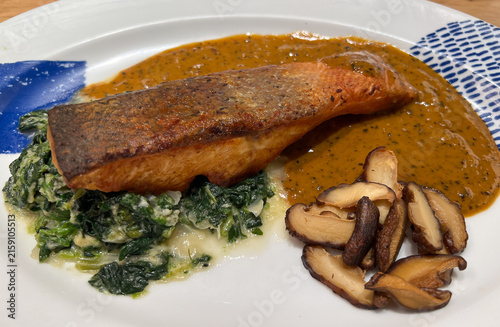 Closeup View of Salmon Steak with Pepper Sauce Mushroom and Spinach