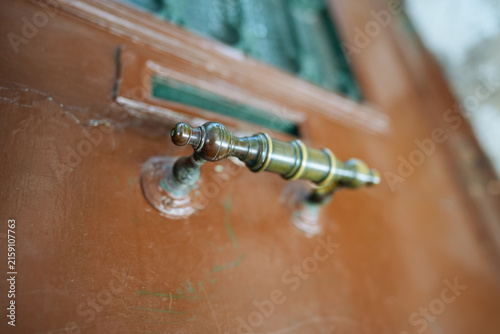 Fotografie Close-up view of a vintage brass door handle on a weathered wooden door in Venic