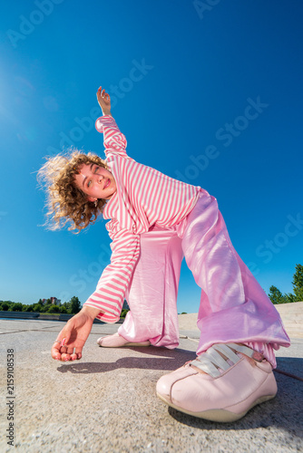 Woman stretching in pink outfit photographed with an ultra wide angle 