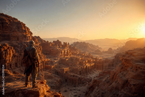 Ancient Desert Ruins at Sunrise: A lone traveler stands on a rocky outcrop, gazing at ancient ruins nestled within a vast desert canyon as the sun rises.