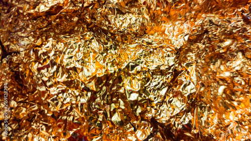 Gold metallic leaf or foil crumpled golden and silver texture background