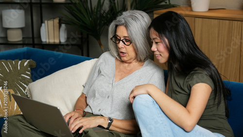 Older woman and young multi ethnic girl connecting and learning with technology at home