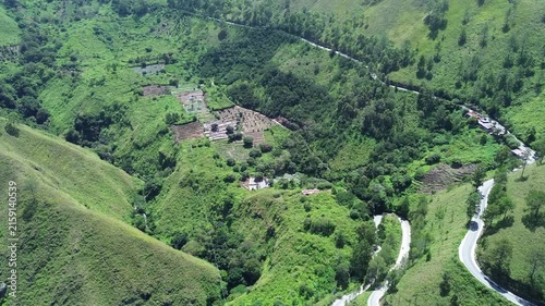 Aerial view of winding road through lush green hills