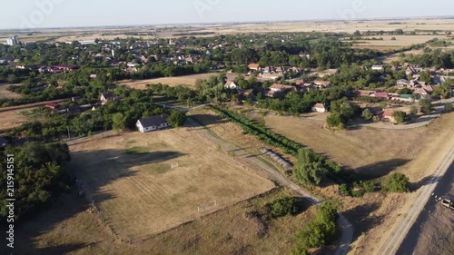 Wide aerial shot of a iron truss railway bridge spanning a river in a lush green countryside. Landscape structure crossing water nature 


