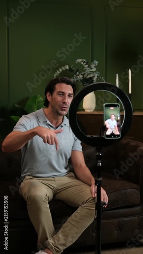 Male influencer speaking to the camera while recording a video for social media from his home