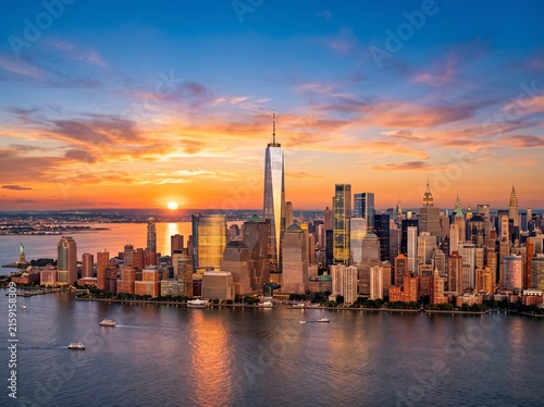 Stunning aerial view of the New York City skyline and One World Trade Center during a vibrant sunset over the Hudson River.