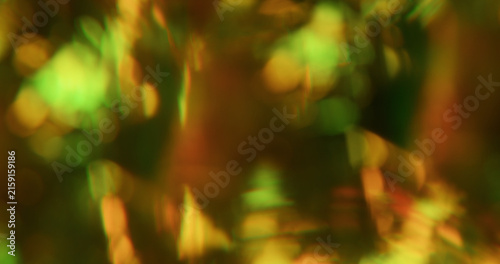 Blur kaleidoscope flare. Green light abstraction. Yellow pink orange colorful round optical gleam on luminous bokeh glisten background.