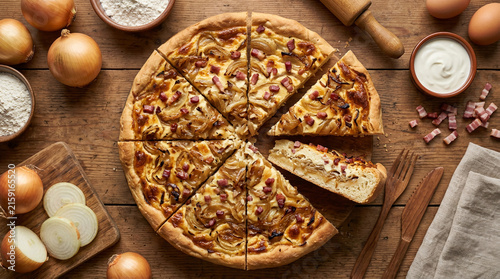 Delicious Traditional Flammkuchen Pizza with Caramelized Onions and Bacon Served on a Rustic Wooden Table